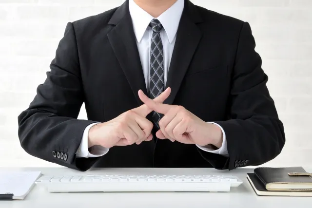 バツ印をつくるビジネスマン