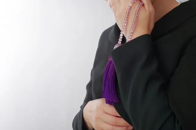 涙を拭く喪服姿の女性